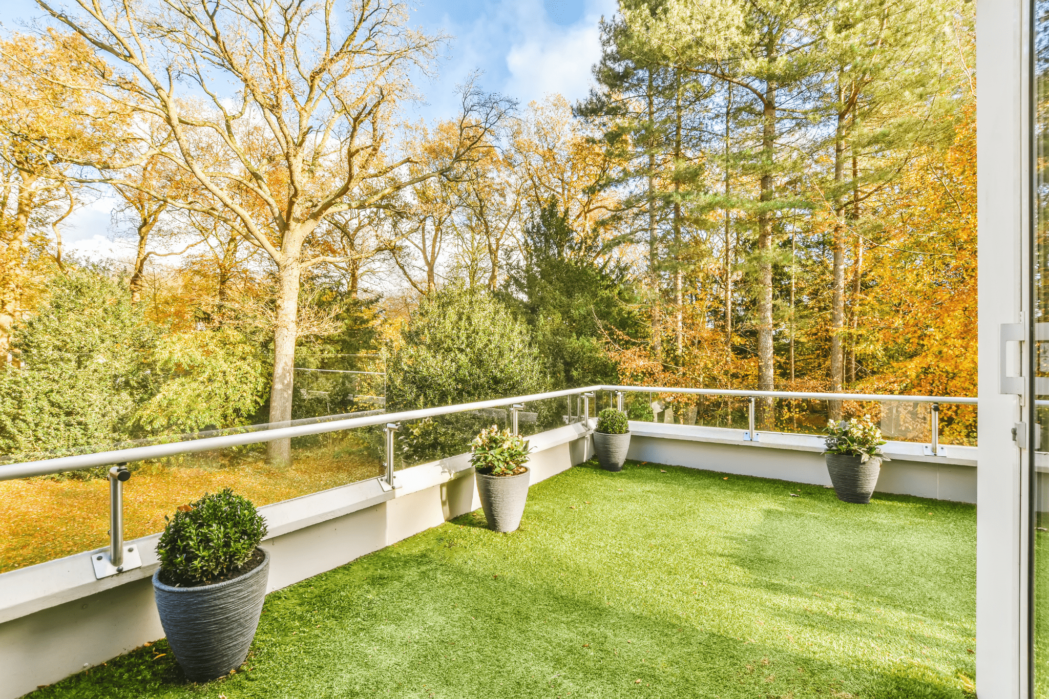 A cozy balcony retreat enhanced with lush green artificial turf for residential homes